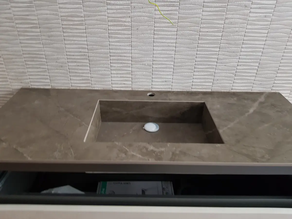 Encimera de baño en porcelánico efecto piedra con lavabo integrado y canto recto
