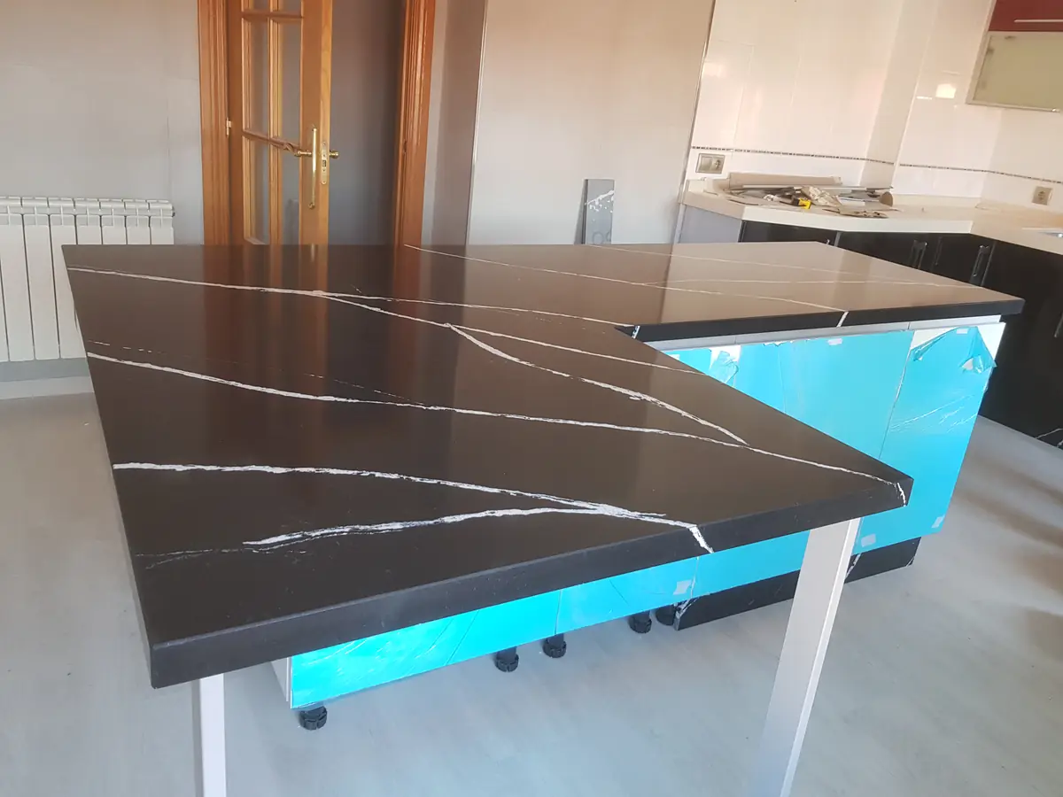 Encimera Silestone negro veteado con canto ingletado y veta continuada en península
