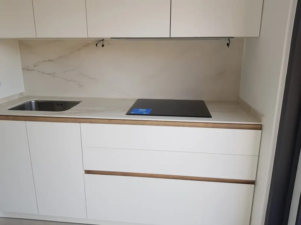 Cocina a medida en León con muebles blancos y encimera porcelánica blanca con veta tipo mármo